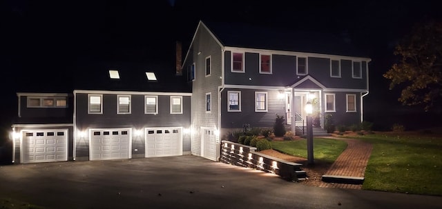 colonial-style house featuring a yard and a garage