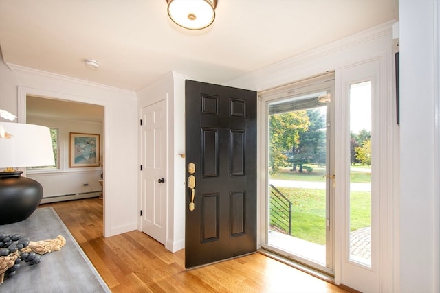 entrance foyer with light hardwood / wood-style floors, crown molding, and baseboard heating