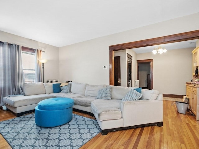 living room with light wood-style floors, baseboards, and a chandelier