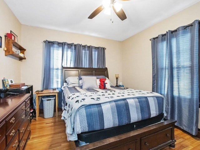 bedroom with multiple windows, ceiling fan, and light wood finished floors