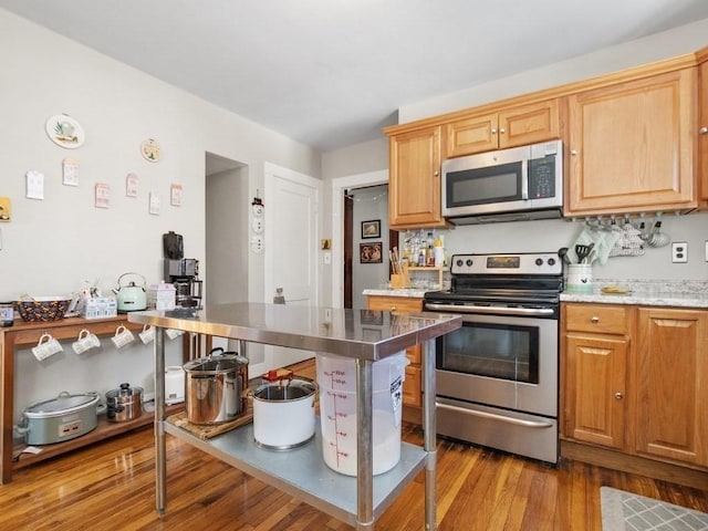 kitchen featuring appliances with stainless steel finishes and wood finished floors