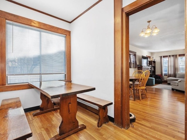 dining area with crown molding, wood finished floors, and a chandelier