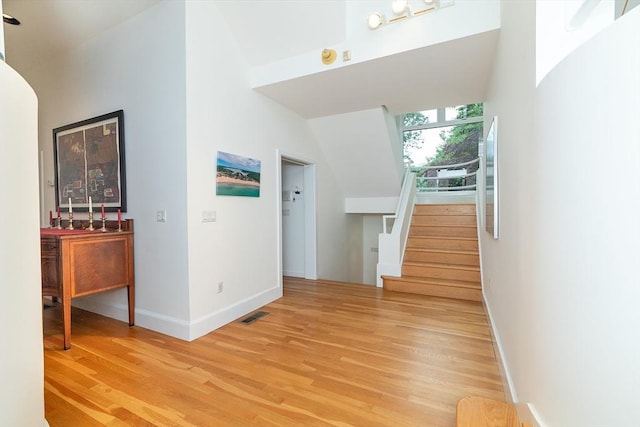 interior space featuring stairs, visible vents, baseboards, and light wood-style floors
