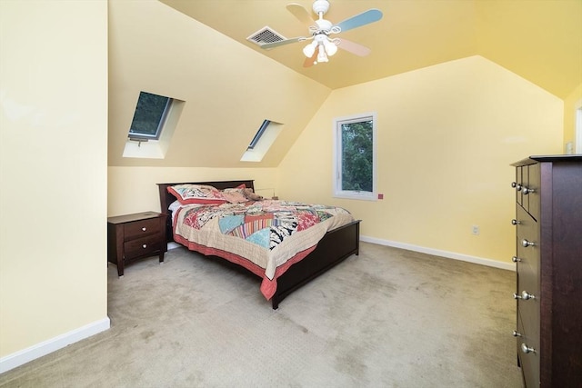 carpeted bedroom featuring visible vents, ceiling fan, baseboards, and vaulted ceiling with skylight