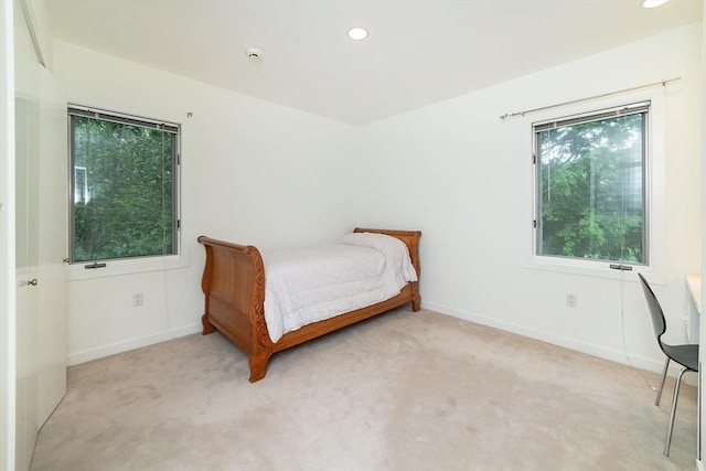 bedroom with recessed lighting, light colored carpet, and baseboards