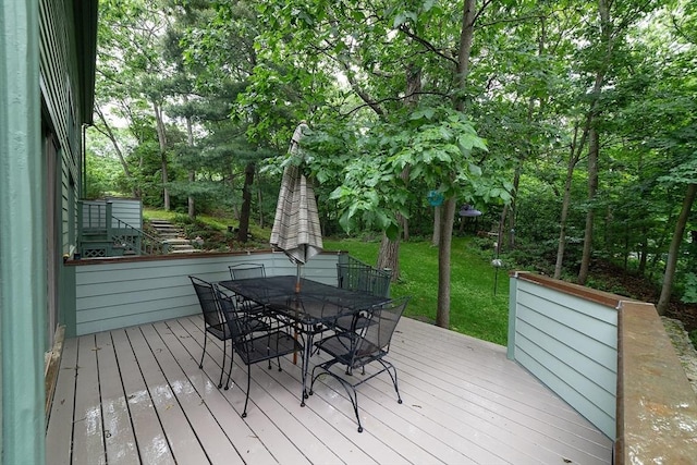 wooden deck with a lawn and outdoor dining space