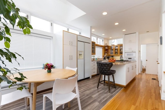 dining space with recessed lighting and light wood-style flooring