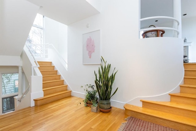 stairs featuring wood finished floors and baseboards
