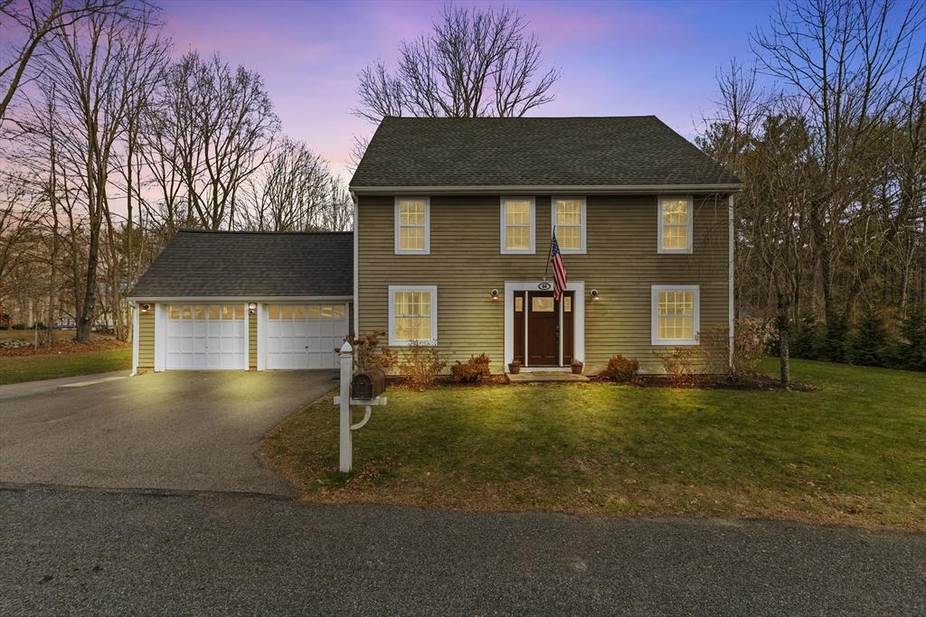 colonial house with a yard and a garage