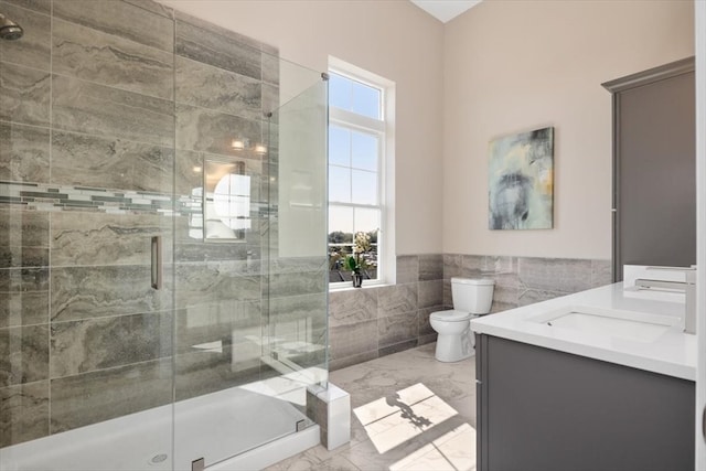 bathroom with walk in shower, tile walls, vanity, and toilet