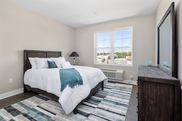 bedroom with wood-type flooring and a wall mounted air conditioner