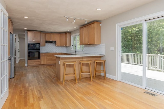 3 Integrity Way, Groton, MA 01450 - kitchen with black appliances, a peninsula, under cabinet range hood, light wood-style floors, and recessed lighting