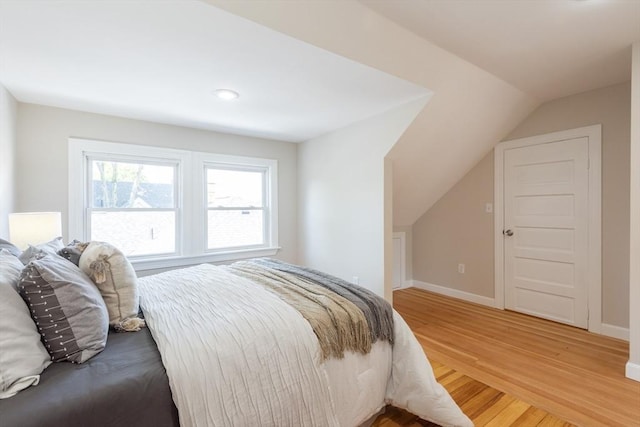 1690 Centre St Unit 2, Boston, MA 02132 - bedroom with light wood finished floors, vaulted ceiling, and baseboards