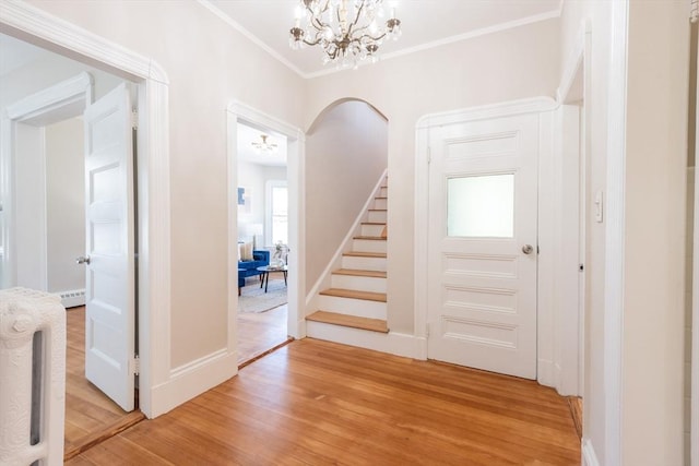1690 Centre St Unit 2, Boston, MA 02132 - foyer entrance with light wood-style flooring, stairs, a chandelier, ornamental molding, and arched walkways