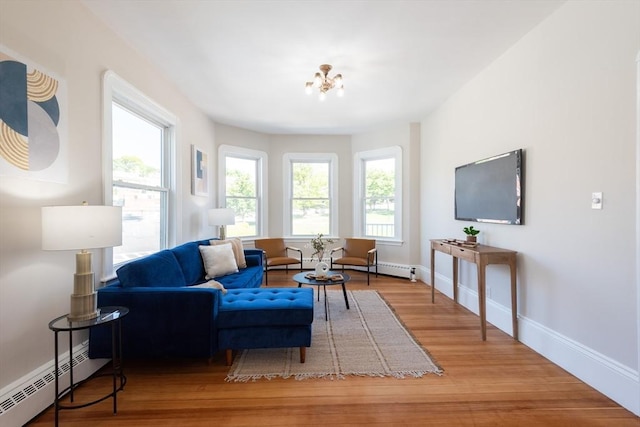 1690 Centre St Unit 2, Boston, MA 02132 - living area with a baseboard heating unit, wood finished floors, baseboards, and a chandelier