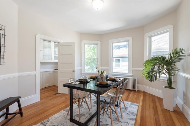 1690 Centre St Unit 2, Boston, MA 02132 - dining room with radiator heating unit, light wood-style floors, and baseboards