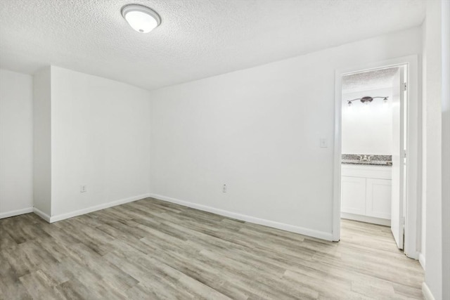 935 S Atlantic Unit 302, Daytona Beach, FL 32118 - spare room featuring a textured ceiling and light wood-type flooring