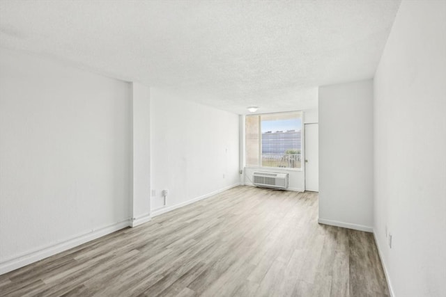 935 S Atlantic Unit 302, Daytona Beach, FL 32118 - empty room with a wall unit AC, wood finished floors, and a textured ceiling