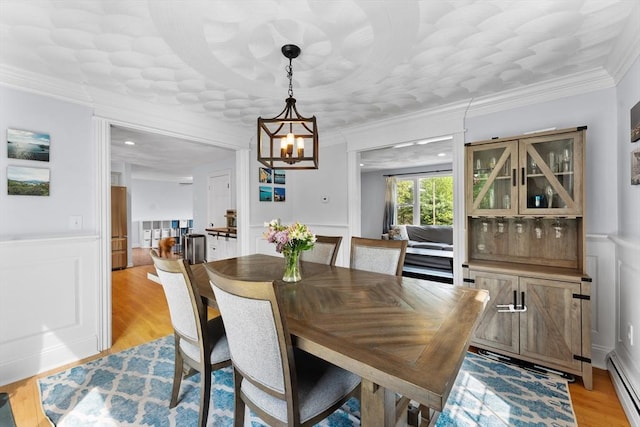 26 Dodge Rd, Sutton, MA 01590 - dining room with a baseboard heating unit, a chandelier, light wood-style floors, wainscoting, and a decorative wall