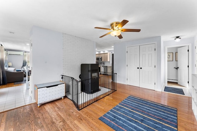 26 Dodge Rd, Sutton, MA 01590 - living area with a baseboard radiator, ceiling fan, an AC wall unit, and wood finished floors