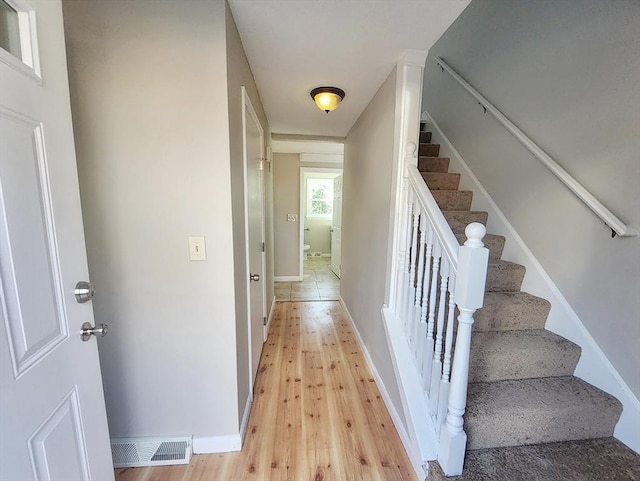 stairs featuring hardwood / wood-style flooring