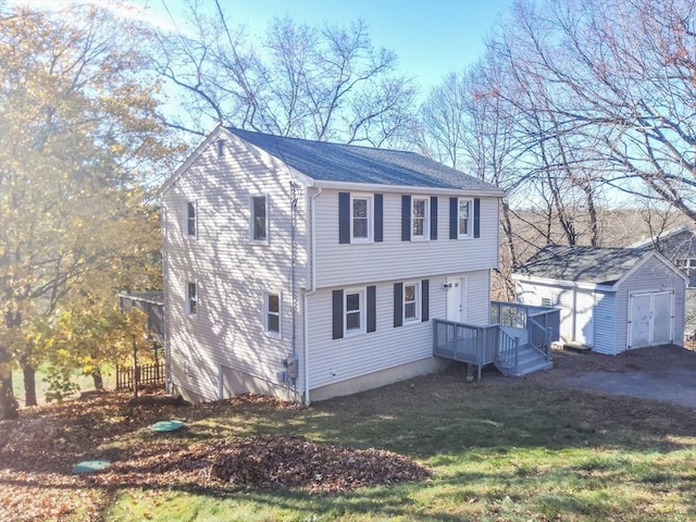 view of front of property with a front yard, a deck, and a storage shed