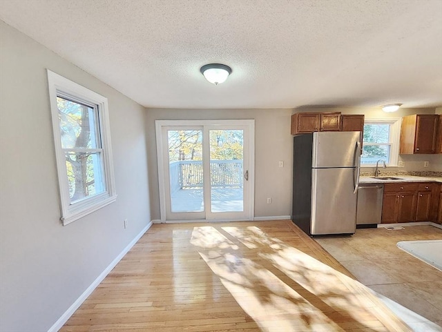 kitchen featuring stainless steel appliances, light hardwood / wood-style flooring, and plenty of natural light