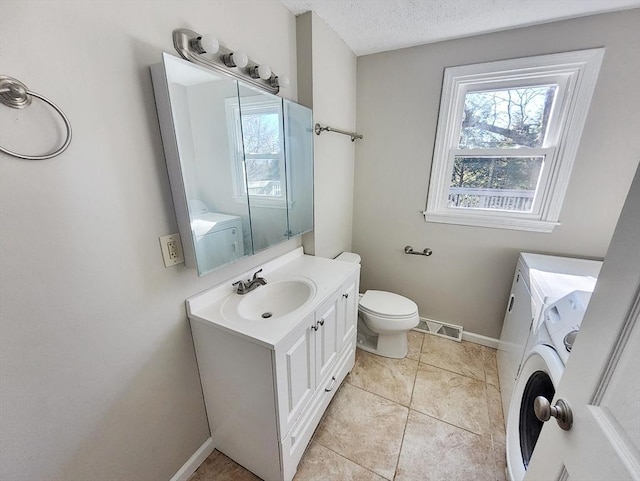 bathroom with tile patterned flooring, vanity, a textured ceiling, and toilet