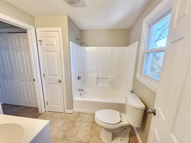 full bathroom featuring vanity, tile patterned floors, washtub / shower combination, toilet, and a textured ceiling