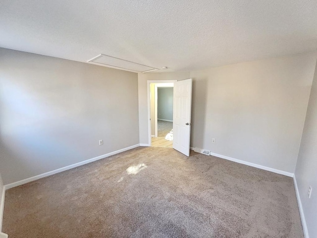 carpeted spare room with a textured ceiling