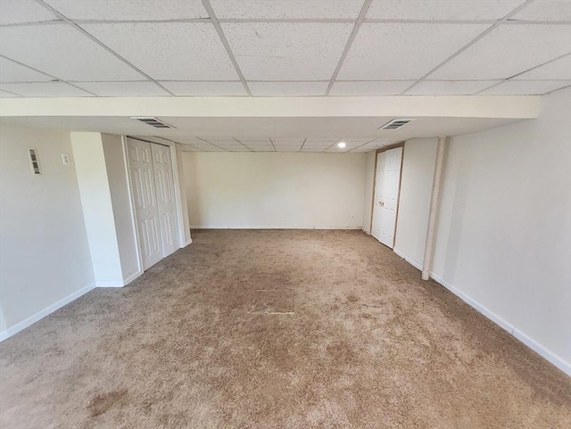 basement featuring carpet floors and a drop ceiling