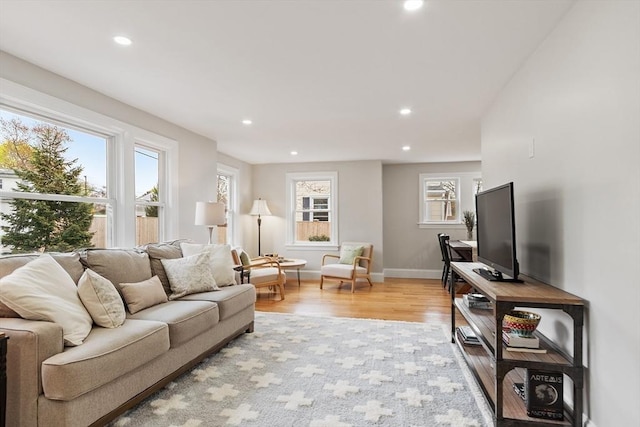 living room with recessed lighting, baseboards, and light wood finished floors