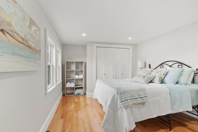 bedroom featuring recessed lighting, baseboards, light wood-style floors, and a closet