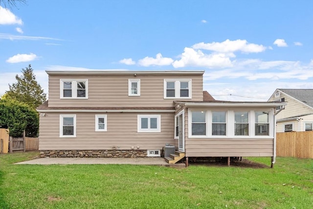 back of house featuring fence, central air condition unit, and a lawn