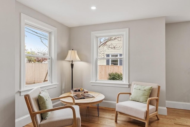 sitting room with baseboards, recessed lighting, and light wood finished floors