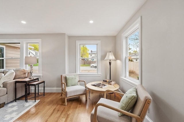 living area featuring baseboards, recessed lighting, a wealth of natural light, and light wood-type flooring