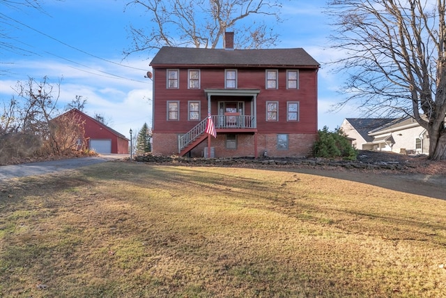 view of front facade with an outbuilding, a garage, and a front yard