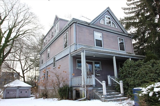 view of front of property featuring an outbuilding, a porch, and a garage