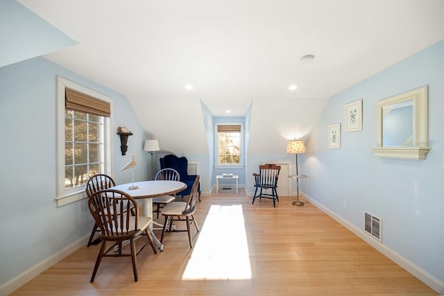 living area featuring lofted ceiling and light hardwood / wood-style floors