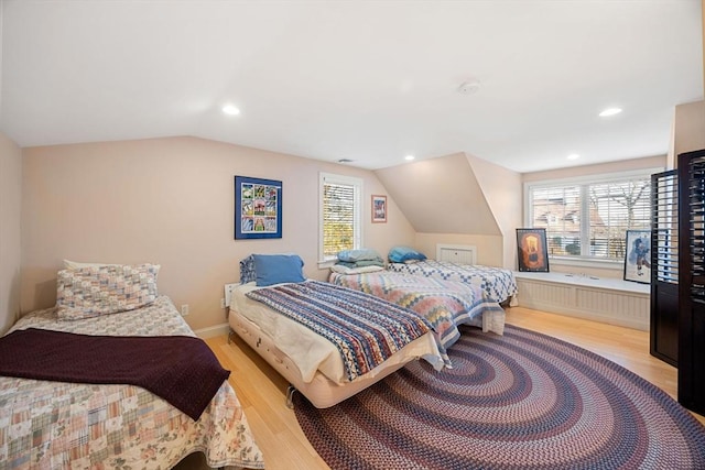 bedroom featuring lofted ceiling and light wood-type flooring