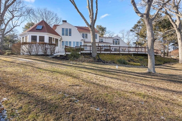 back of house featuring a sunroom, a yard, and a deck