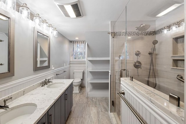 bathroom featuring vanity, toilet, and a shower with door