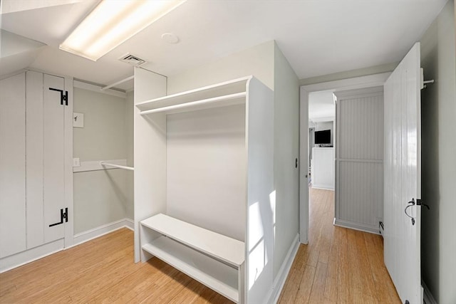 walk in closet with light hardwood / wood-style floors