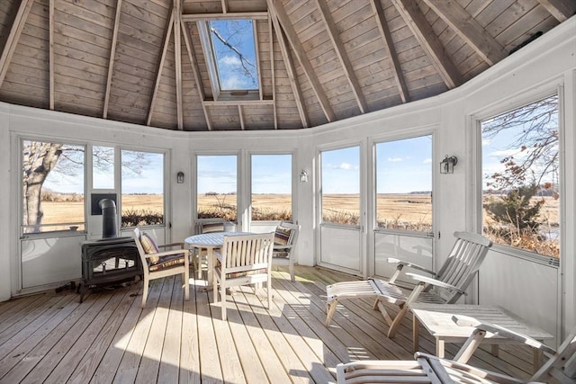 sunroom featuring vaulted ceiling with beams, a rural view, wooden ceiling, and a wood stove