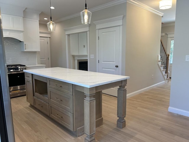 6 Knott St, Attleboro, MA 02703 - kitchen with stainless steel gas range, a fireplace, light wood-style floors, tasteful backsplash, and ornamental molding