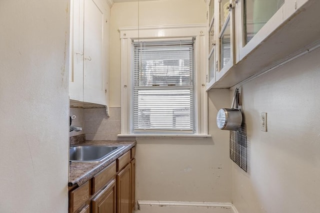 kitchen with backsplash, brown cabinets, and a sink