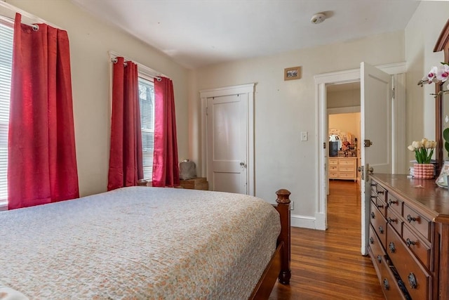 bedroom with dark wood-type flooring and baseboards