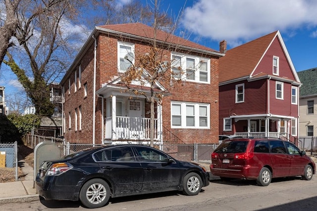 view of front facade with fence and brick siding