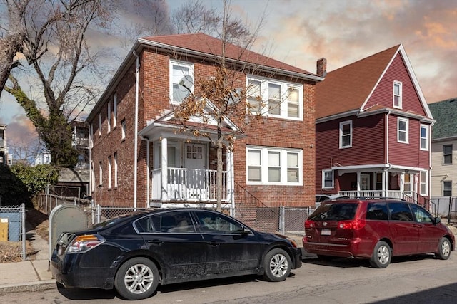 view of front of house featuring a fenced front yard, brick siding, and a chimney