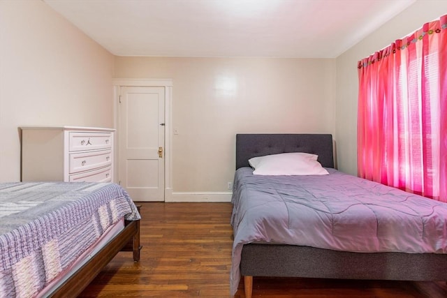 bedroom with baseboards and wood finished floors